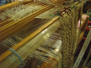 Pile chains over a tube lashed to the back of the loom.  That lease stick stayed in for the whole project